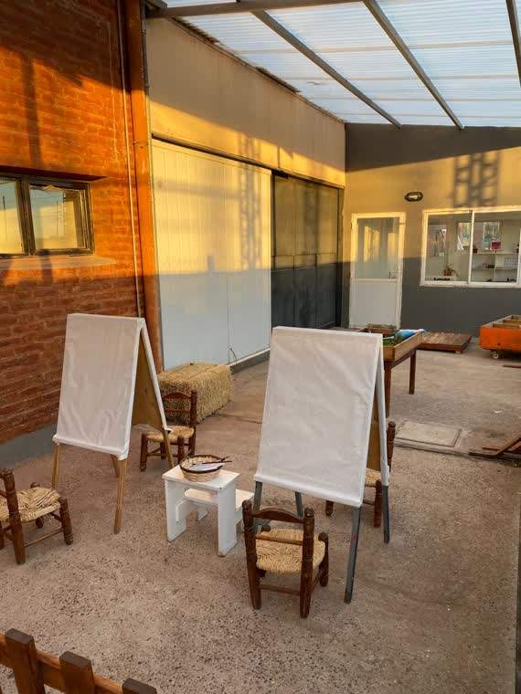 Atelier del jardín con caballetes de pintura y sillas de madera