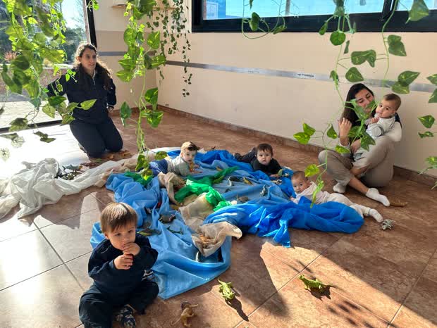Docente acompañando a los bebés en la sala de lactantes